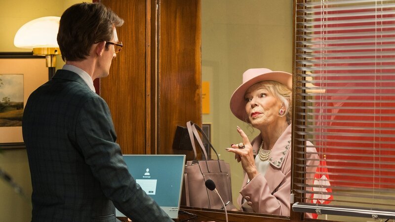 Unsere kleine Botschaft Staffel 1 Folge 2 Erster Schalterdienst als Feuerprobe für den neuen Vize-Botschafter: Jonas Gygax als Vize-Botschafter Adi, Birgit Steinegger als Frau Zybach. Regie: Johannes Bachmann, Johannes Schroeder Produktion: Fidelio Films GmbH Kamera: Orit Teply Drehbuch: Pascal Glatz, Christian Wehrlin – Bild: SRF/​Pascal Mora