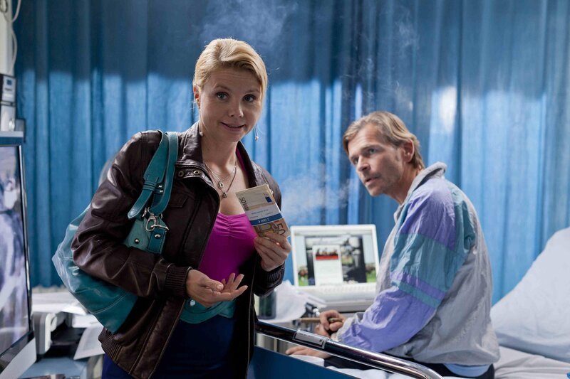 Jens Plesse (Tonio Arango, r.) bittet Danni (Annette Frier, l.) um Hilfe, denn er betreibt aus dem Krankenbett heraus ein blühendes Geschäft mit Sportwetten, was ihm Oberarzt Dr. Meier verbieten will. – Bild: SAT.1 /​ Frank Dicks