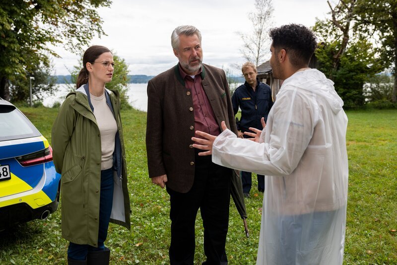 Aufgeregt erklärt Dominik Meis (Younes Tissinte, r.) den Hauptkommissaren Beck (Michaela Weingartner, l.) und Stadler (Dieter Fischer, 2.v.l.) sowie Polizeihauptmeister Mohr (Max Müller, 2.v.r.), wie er zufällig am Seeufer einen Toten gefunden hat. – Bild: ZDF und Linda Gschwentner