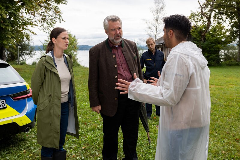 Aufgeregt erklärt Dominik Meis (Younes Tissinte, r.) den Hauptkommissaren Beck (Michaela Weingartner, l.) und Stadler (Dieter Fischer, 2.v.l.) sowie Polizeihauptmeister Mohr (Max Müller, 2.v.r.), wie er zufällig am Seeufer einen Toten gefunden hat. – Bild: ZDF und Linda Gschwentner