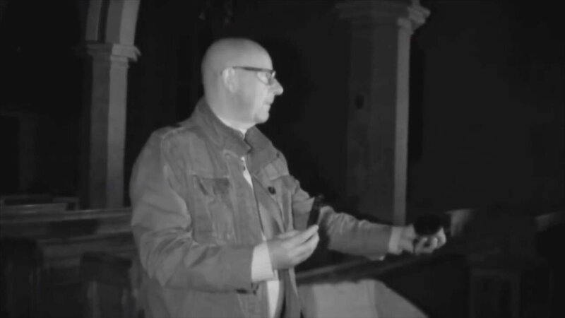 A paranormal investigator looks for ghosts inside a medieval church at nighttime in Buckinghamshire, England – Bild: Jeff Young
