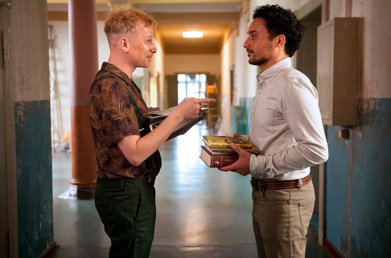 Titus (Robert Stadlober, links) nimmt die Herausforderung an, Haschim (Omar El-Saeidi) zu beweisen, dass es deutschen Humor gibt. – Bild: BR/​Novafilm Fernsehproduktion/​Alva Nowak