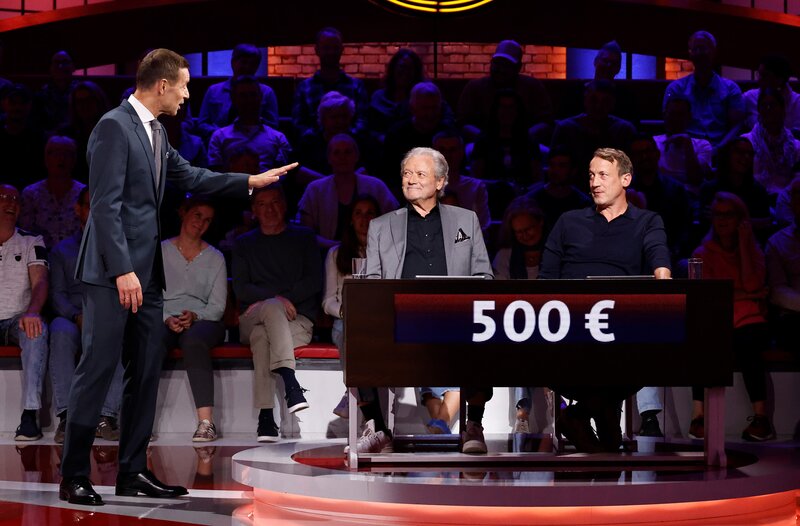 Moderator Kai Pflaume (l.) mit seinem Rateteam-Kapitän Wotan Wilke Möhring (r.) und dem ehemaligen Eiskunstläufer und Schauspieler Hans-Jürgen Bäumler (M.). – Bild: ARD/​NDR/​UFA SHOW & FACTUAL/​Morris Mac Matzen