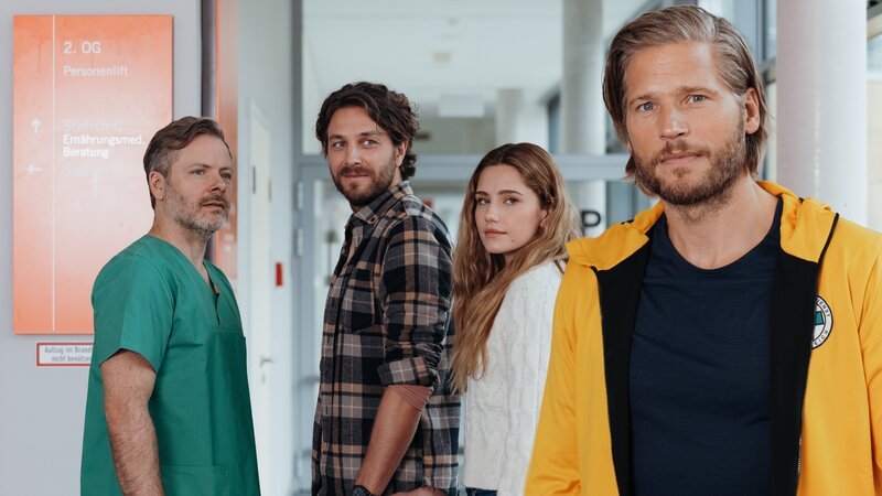 Nach den positiven Nachrichten von Dr. Nick Aichstetter (Nicholas Reinke, l.) steht der Hochzeit von Sofia Conti (Mitsou Jung, 2.v.r.) und Stefan Bergstätter (Frederik Götz, 2.v.l.) nichts mehr im Weg. Und Markus Kofler (Sebastian Ströbel, r.) kommt dabei eine besondere Ehre zuteil. – Bild: ZDF und Sabine Finger Fotografie