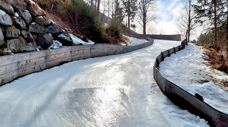 In der Nähe von Garmisch-Partenkirchen trainieren die Geschwister Ruby und John Naturbahnrodeln. Ende Februar wollen sie an Wettkämpfen teilnehmen. Zwar ist gerade Winter, aber noch im letzten Monat waren die Wiesen überwiegend grün und ihre Heimbahn ohne Schnee. Bei stellenweise zweistelligen Temperaturen mussten sie daher weit in die Alpen fahren, um auf eine Natureisbahnen üben zu können. – Eisbahn Ried im Oberinntal – Bild: rbb/​Frank Kleemann
