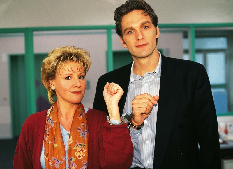 Schwester Nikola (Mariele Millowitsch) und Dr. Schmidt (Walter Sittler) in Handschellen aneinander gekettet: Die beiden demonstrieren, was wahre Teamarbeit bedeutet. – Bild: RTL