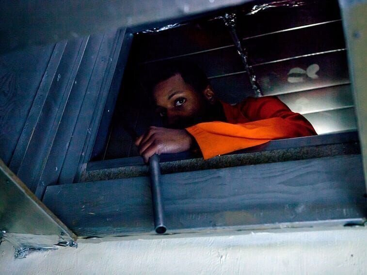 Taylor climbs through removed cell bars on a vent. Taylor ditches his partner when Reed decides to rest on a bench because he is exhausted. – Bild: Photograph by BK3 Productions/​Diego Garcia