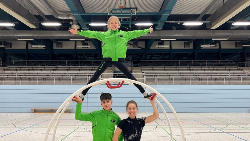 Checkerin Marina landet diesmal bei Johanna und Luis, die ihr Rhönradturnen beibringen. – Bild: BR/​megaherz GmbH/​Amelie Cran