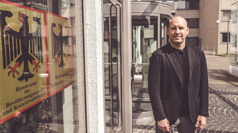 Reporter Sebastian Galle vor dem Bundesamt für Bevölkerungsschutz und Katastrophenhilfe in Bonn. – Bild: ZDF