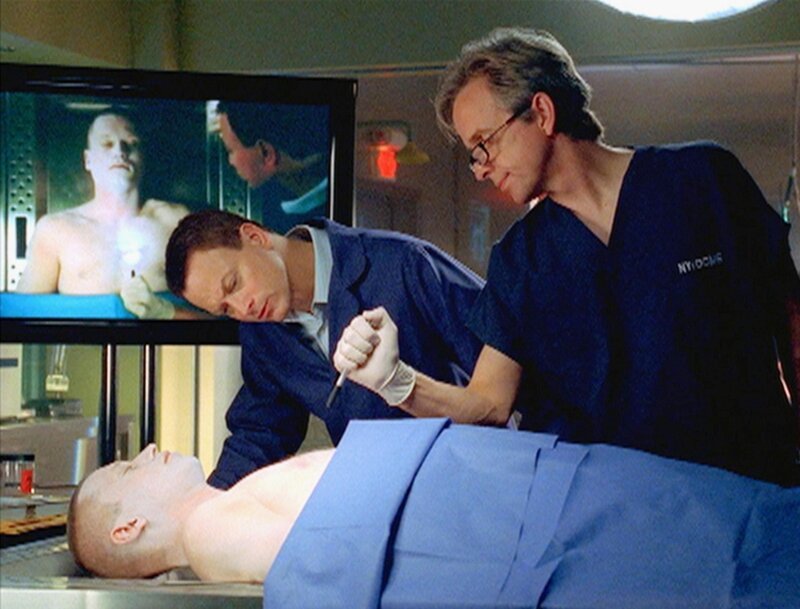 Dr. Hammerback (Robert Joy, r.) und Detective Taylor (Gary Sinise) untersuchen den Leichnam von Corporal Price (Darstellername unbekannt). – Bild: RTL