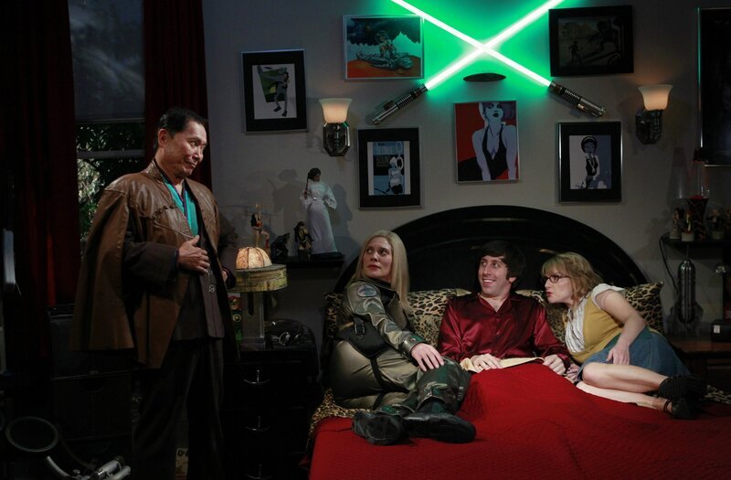 Als Howard (Simon Helberg, 2.v.r.) sich seinen abendlichen Fantasien mit Katee Sackhoff (Katee Sackhoff, 2.v.l.) hingeben will, durchkreuzt zunächst die imaginäre Bernadette (Melissa Rauch, r.) seine Pläne, dann zu seiner Verwirrung auch George Takei (George Takei, l.) … – Bild: Warner Bros. Television