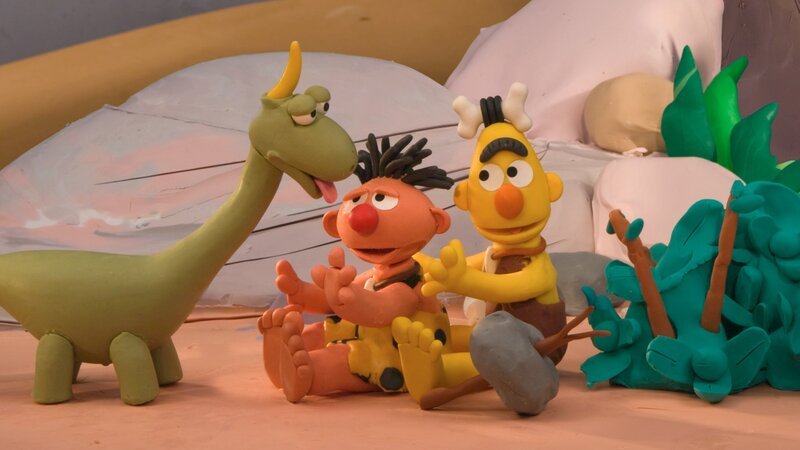 Ernie und Bert sind Höhlenmenschen und wollen für ihren Hausdino Spot eine Hütte oben auf einem Hügel bauen. – Bild: NDR/​Sesameworkshop