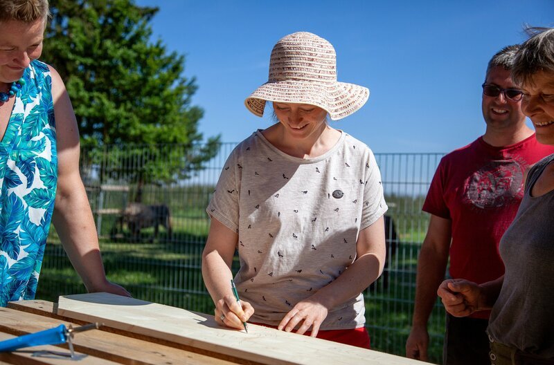 Die Landfrauen schreiben ihre Namen auf das Holzbrett für das Insektenhotel. v.li.: Marion Bohner, Julia Maisch, Martin Stein, Rosa Bucheli – Bild: SWR/​Anne Deiß