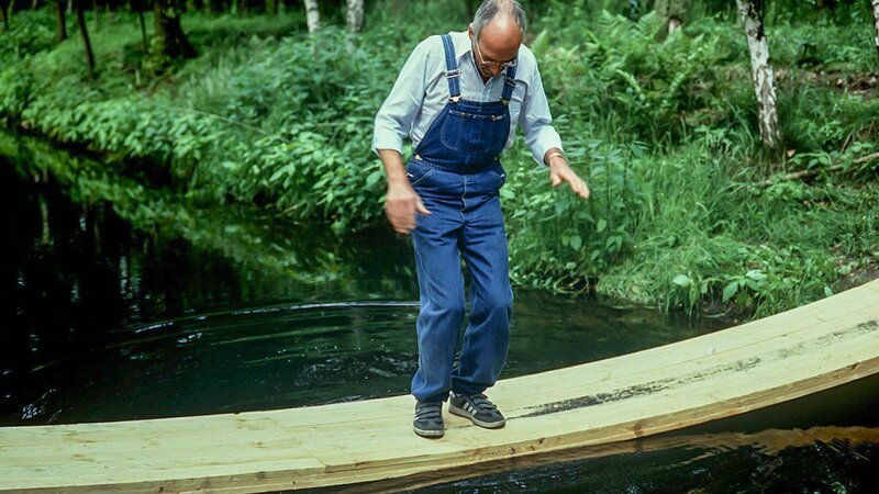 Peter Lustig (Peter Lustig) will eine Brücke über den Bach bauen – welche Konstruktion ist stabil und bringt ihn sicher ans andere Ufer? – Bild: ZDF und Christiane Pausch