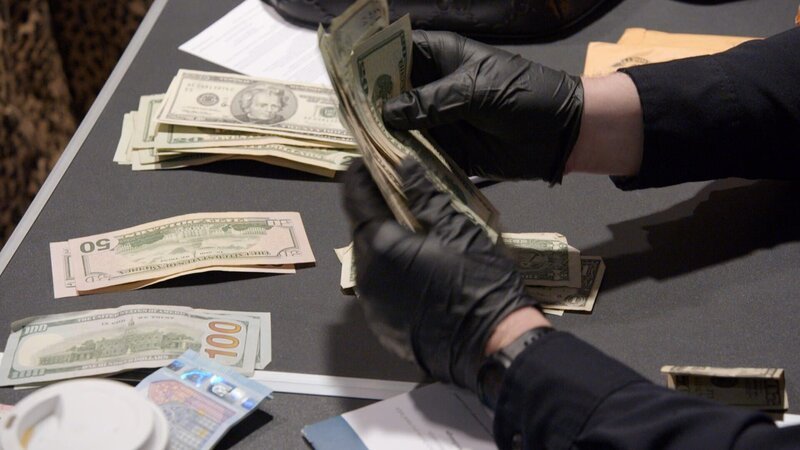 CBP-Beamte, die am Philadelphia International Airtport in Philadelphia nach nicht deklariertem Geld Ausschau halten, zählen Geldscheine. (National Geographic) – Bild: National Geographic /​ Disney