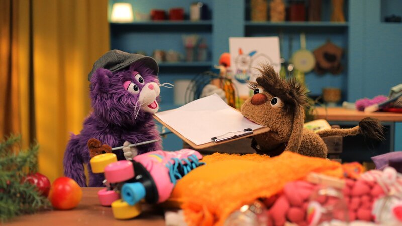 MiWau und Moppi räumen gemeinsam das Chaos auf Moppis Schlafplatz auf. – Bild: rbb/​Anderthalb