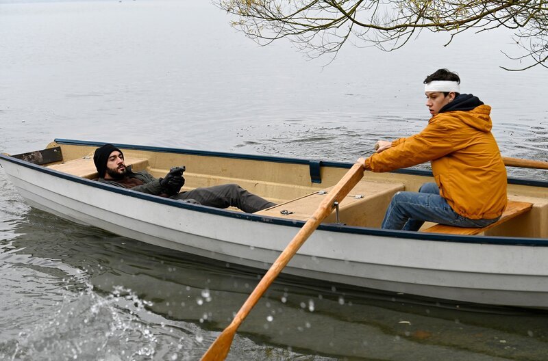 Der Entführer (Eidin Jalali, l.) zwingt Niklas Fehrenbach (Noah Calvin, r.) über den Bodensee zu rudern. – Bild: ARD/​Laurent Trümper