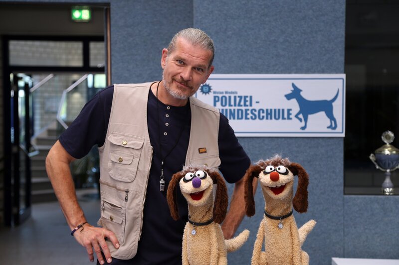 Die Erdmännchen verkleidet mit Hundetrainer Götz Otto. – Bild: NDR/​bigSmile