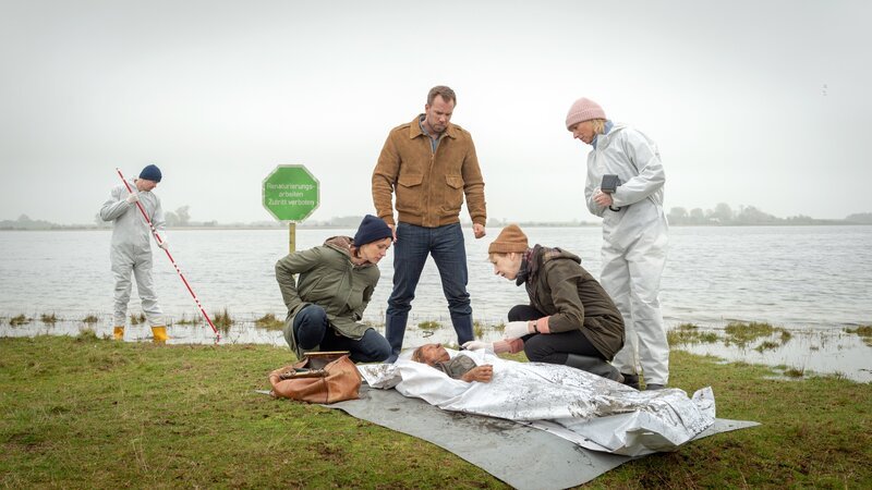 Die Lehrerin Melanie Reusdorf (Anne Baus, M.) ist vor Monaten verschwunden. Doch nun ist die Leiche der Frau im Moor aufgetaucht. Die Kommissare Joost (Nike Fuhrmann, l.) und Pöhlmann (Dominic Boeer, 2.v.l.), Kriminaltechnikerin Roswitha Prinzler (Silke Matthias, r.) und Rechtsmedizinerin Helene Sturbeck (Katharina Blaschke, 2.v.r.) nehmen die Arbeit auf. Können sie den Mörder der engagierten Grundschullehrerin finden? Warum musste die junge Frau sterben? – Bild: ZDF und Marc Meyerbröker