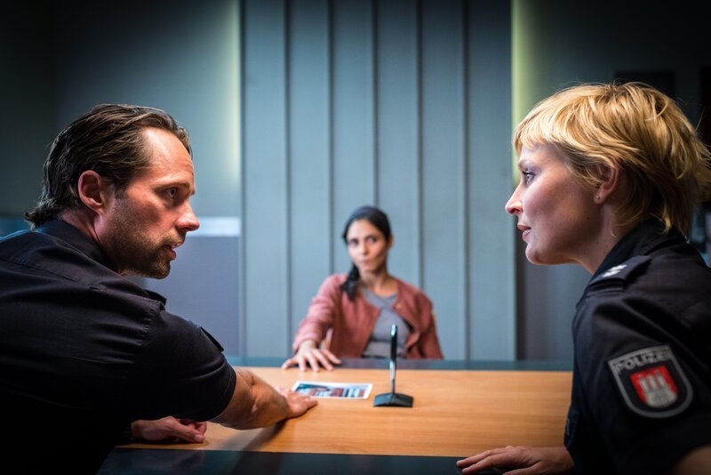 Mattes (Matthias Schloo, l.) und Melanie (Sanna Englund, r.) wollen von Mina (Pegah Ferydoni, M.) wissen, wo deren Bruder ist. – Bild: ZDF/​Boris Laewen