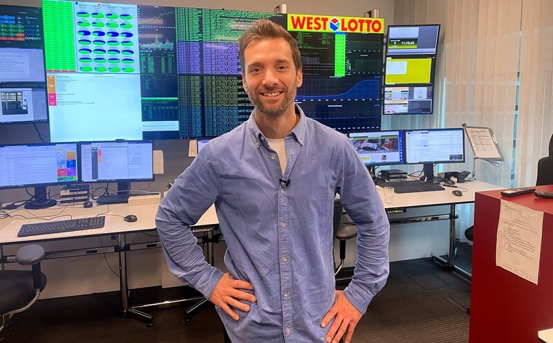 Die meisten Neu-Millionäre gab es in Nordrhein-Westfalen. Gleich 45 Menschen wurden in der WestLotto-Zentrale in Münster erfasst und nach dem Gewinn vor Ort betreut. – Reporter Daniel Aßmann in der WestLotto-Zentrale. – Bild: WDR/​Bavaria Entertainment GmbH/​Lukas Feyder