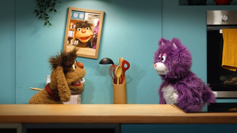 Moppi und MiWau stehen vor seinem Bild an der Wand – und das hängt ganz schief! – Bild: rbb/​Anderthalb