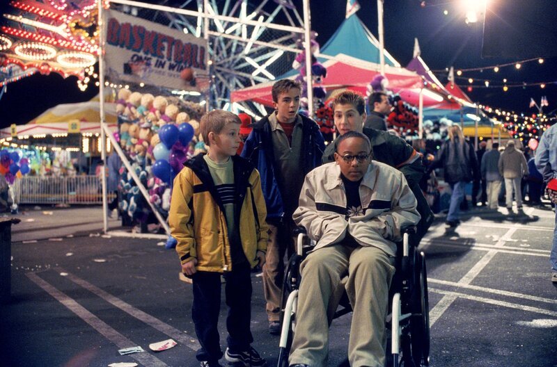 Auf dem Jahrmarkt entdecken Dewey (Erik Per Sullivan, l.), Malcolm (Frankie Muniz, 2.v.l.), Stevie (Craig Lamar Traylor, r.) und Reese (Justin Berfield, 2.v.r.) die Geisterbahn … – Bild: ViacomCBS