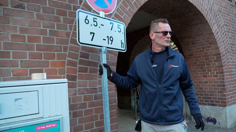 Umzugsmitarbeiter Mario Weichler stellt ein Halteverbotsschild für den Umzug des Stadtarchivs auf. – Bild: NDR