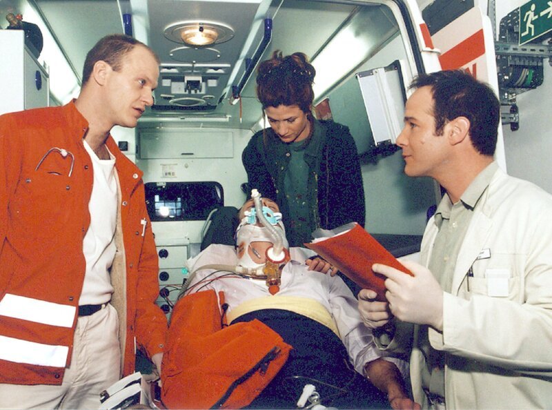 Nach einem Treppensturz läßt Iris (Astrid M. Fünderich) ihren Freund Jan (Christoph Grunert) in die Sachsenklinik einliefern. Notarzt Schäfer (Lutz Schäfer, rechts) und Dr. Kreutzer (Johannes Steck) leiten die notwendigen Maßnahmen sofort ein. – Bild: MDR/​Krajewski