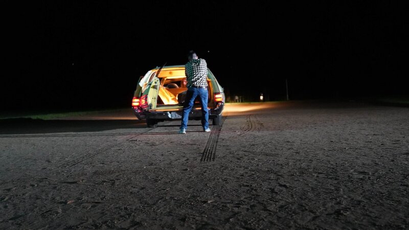 Recreation of William Houle pulling rug out of station wagon – Bild: Warner Bros. Discovery, Inc. or its subsidiaries and affiliates. All rights reserved.