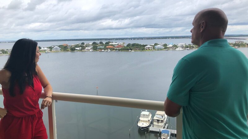 Contributors and agents, Amanda Hurd (L) and Gene Hurd (R) check out the breathtaking views of the ocean from the balcony while touring Pensacola Penthouse as seen on HGTV’s Beachfront Bargain Hunt. – Bild: Discovery, Inc.