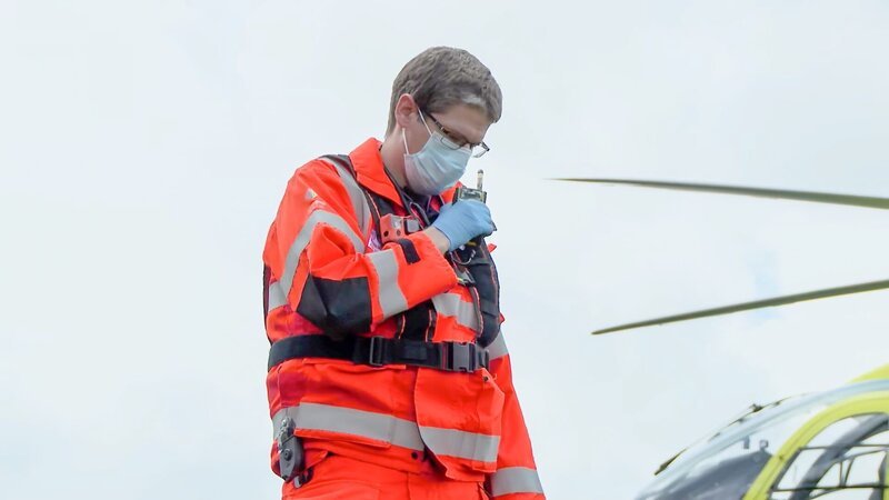 Paramedic Sam Burgess talking into his walkie talkie to let the hospital know that a patient is on their way – Bild: Discovery, Inc.