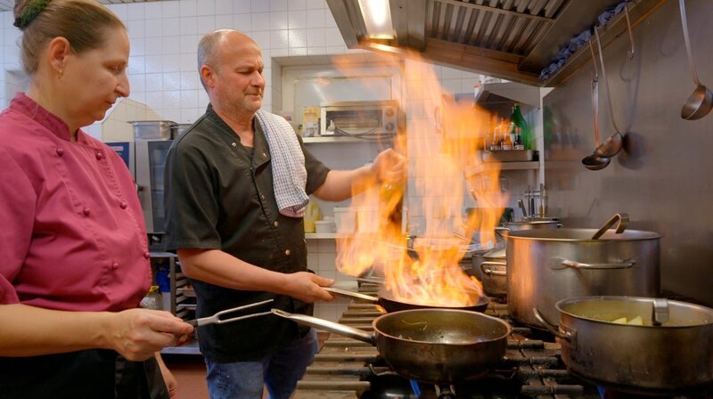 Wirt Günther Putz flambiert die Madeira-Soße, während Sous-Chefin Sonja Brummer assistiert. Weiteres Bildmaterial finden Sie unter www.br-foto.de. – Bild: BR/​Raimund Lesk