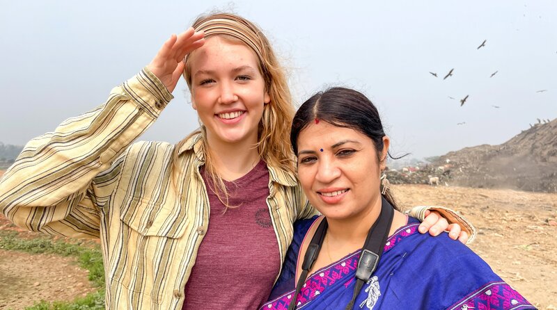 Nina (links) und Artenschützerin Purnima sehen sich auf einer Mülldeponie um. Hier suchen viele der bedrohten Argala-Marabus nach Nahrung. (Purnima Devi Barman). – Bild: BR/​Text und Bild Medienproduktion GmbH & Co. KG