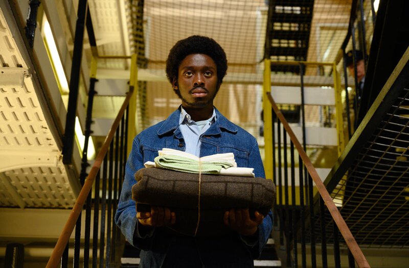 Alex Wheatle (Sheyi Cole) auf seinem Weg in die Gefängniszelle. – Bild: WDR/​McQueen Limited