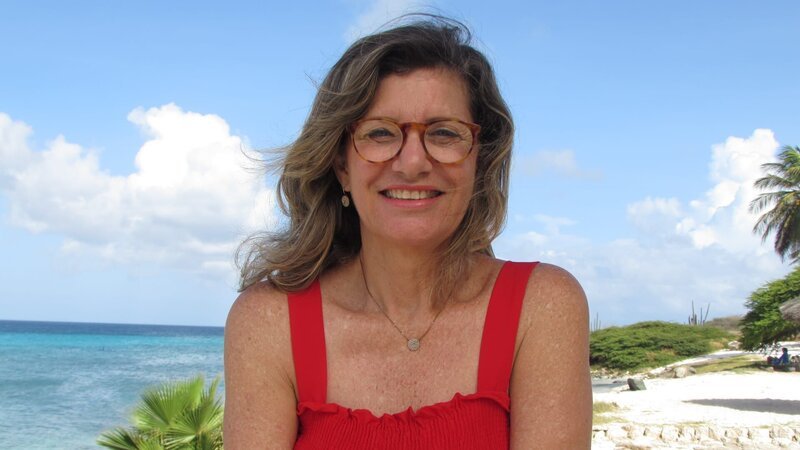 Exterior, Client Holly posing in front of beach in Aruba. As seen on HGTV’s Caribbean Life – Bild: Scripps Networks, LLC. All Rights Reserved.