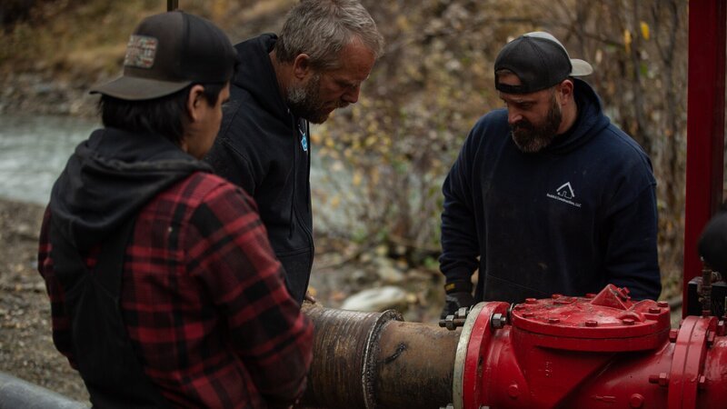 L-R: Trey Charlie, Buzz Legault, Ryan Kent fitting water intake hose with pipe adaptor to pump – Bild: Jake Brown /​ Discovery Channel /​ Discover Images: GLRSH1421_20230 /​ © 2024 Warner Bros. Discovery, Inc. or its subsidiaries and affiliates. All rights reserved.