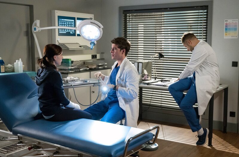 Ben Ahlbeck (Philipp Danne, M.) will mit weiteren Tests herausfinden, was Sina (Isabel Bongard, l.) fehlt. Dr. Matteo Moreau (Mike Adler, r.) hält sie für völlig gesund. – Bild: ARD/​Jens Ulrich Koch