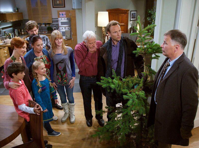 Das Weihnachtsfest soll in diesem Jahr ein Riesen-Familienfest werden. Roland Heilmann (Thomas Rühmann, rechts) und Martin Stein (Bernhard Bettermann, 2. von rechts) wollten den Baum besorgen, doch beide haben erst so spät daran gedacht, dass sie nun mit einem sehr, sehr armseligen Bäumchen in die geschockten Gesichter der versammelten Familie blicken. (Von links: Anthony Petrifke; Hendrikje Fitz; Ella Zirzow; Ursula Karusseit; Karsten Kühn; Henriette Zimmeck; Rolf Becker). – Bild: MDR/​Wernicke