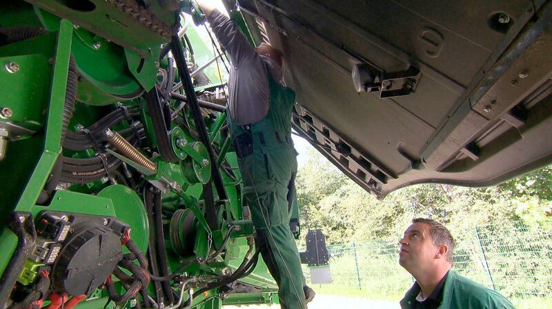 Gelernt ist gelernt: Azubi Jannis steckt bis über beide Ohren in der Maschine, begleitet von Ausbilder Christian – tägliche Routine bei der Ausbildung zum Land- und Baumaschinenmechatroniker. – Bild: WDR /​ WDR Kommunikation/​Redaktion Bild