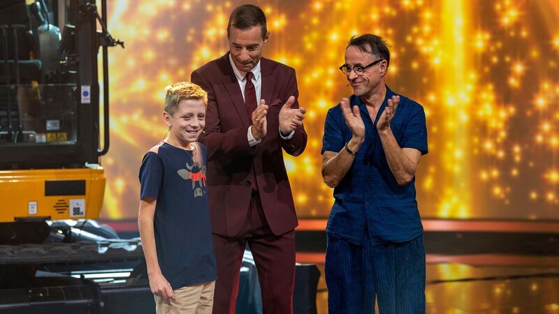 Klein gegen Gross Joel aus Giswil im Kanton Obwalden mit Moderator Kai Pflaume und Schauspieler Jan Josef Liefers. – Bild: SRF/​NDR/​Thorsten Jander