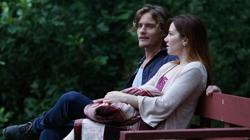 A young woman and man sit on a bench. – Bild: Discovery Communications