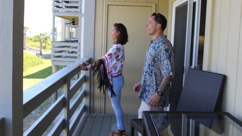 Contributors Carlos Perez (R) and Estefania Perez (L) are in awe of the incredible views from the balcony at Lighthouse Point as seen on HGTV’s Beachfront Bargain Hunt. – Bild: Jay Gao /​ HGTV /​ Scripps (Focus)