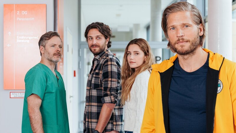 Nach den positiven Nachrichten von Dr. Nick Aichstetter (Nicholas Reinke, l.) steht der Hochzeit von Sofia Conti (Mitsou Jung, 2.v.r.) und Stefan Bergstätter (Frederik Götz, 2.v.l.) nichts mehr im Weg. Und Markus Kofler (Sebastian Ströbel, r.) kommt dabei eine besondere Ehre zuteil. – Bild: ZDF /​ ORF /​ Sabine Finger