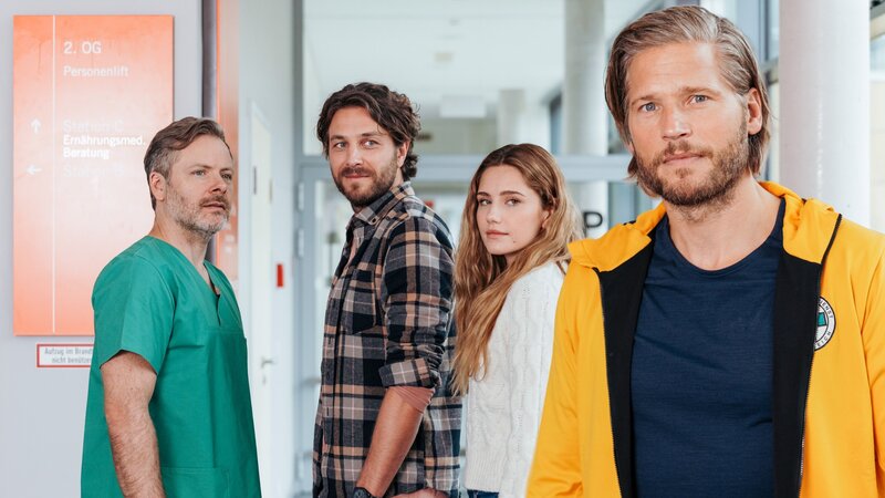 Nach den positiven Nachrichten von Dr. Nick Aichstetter (Nicholas Reinke, l.) steht der Hochzeit von Sofia Conti (Mitsou Jung, 2.v.r.) und Stefan Bergstätter (Frederik Götz, 2.v.l.) nichts mehr im Weg. Und Markus Kofler (Sebastian Ströbel, r.) kommt dabei eine besondere Ehre zuteil. – Bild: ZDF /​ ORF /​ Sabine Finger