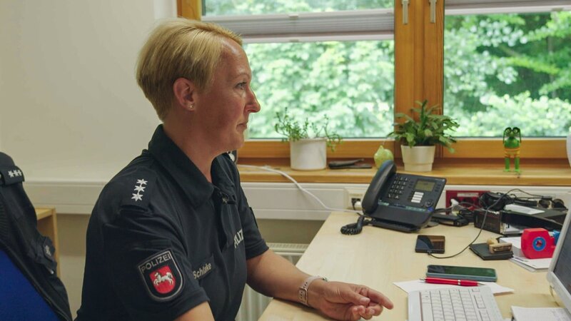 Anke Schlake sitzt vor einem PC – Bild: Warner Bros. Discovery, Inc. or its subsidiaries and affiliates. All rights reserved.