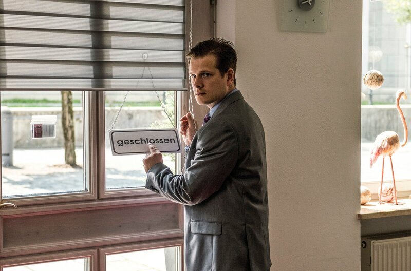 Filialleiter Lux (Enno Hesse) steht an der Ladentür und sperrt ab. – Bild: „Bild: ARD/​Susanne Bernhard (S2). ARD-Programmdirektion/​Bildredaktion
