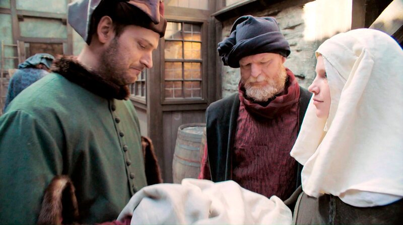 Zwei Männer und eine Frau in historischer Kleidung auf dem Marktplatz. (Spielszene) – Bild: WDR/​Mirella Pappalardo/​Story House Productions