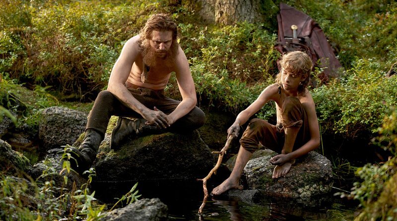 Borka (Sverrir Gudnason) lebt mit seinem Sohn Birk (Jack Bergenholtz Henriksson, re.) in den Wäldern. – Bild: 2023 Viaplay Group/​Filmlance International AB/​Film i Väst/​Ahil Films/​ARD Degeto Film/​Audrius Solominas