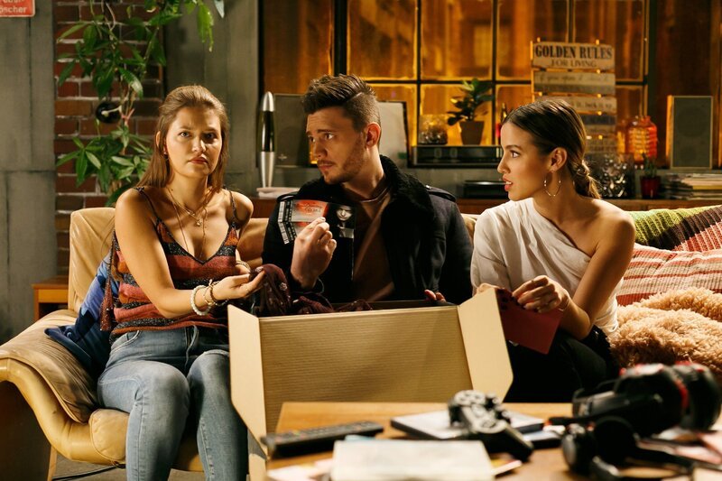 Nathalie (Amrei Haardt, l.) ist sprachlos, als sie im Beisein von Ronny (Bela Klentze) und Chiara (Alexandra Fonsatti) eine extravagante Einladung zu einem Date mit Maximilian bekommt. – Bild: RTL /​ Kai Schulz